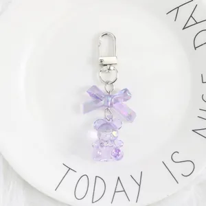 Detail of cute purple resin bear keychain with bow and silver metal clip closure