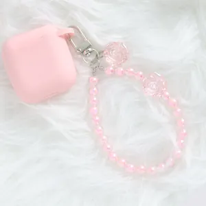 Detail of pink crystal flower keychain on soft white fur for bags or AirPods cases