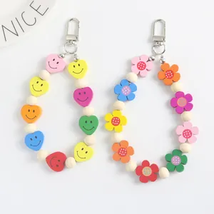 Dettaglio di portachiavi in perline di legno con motivi colorati di cuori e fiori e ganci