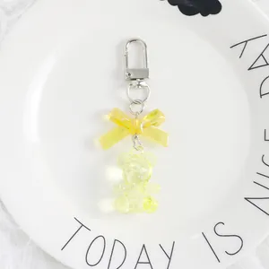 Detailed view of yellow translucent resin bear keychain with bow and silver metal clasp