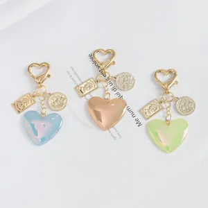 Glitter heart resin keychains in blue, pink, and green with golden metal coin charms