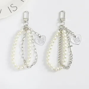 Détail du porte-clés à double chaîne de perles et argent avec breloque en cœur