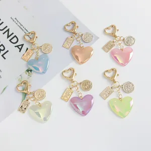 Detailed view of colorful glitter heart keychains with gold charms on white background