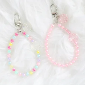 Detail of colorful crystal flower bead keychains with silver lobster clasps on plush fabric