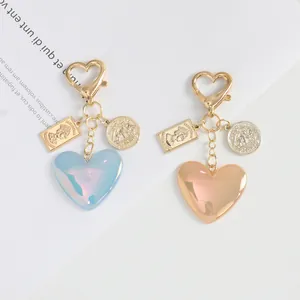 Close-up of heart-shaped glitter keychains with gold resin coins and alloy lobster clasps