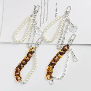 Détail de porte-clés chaîne en métal avec perles, pendentifs cœur et maillons acrylique