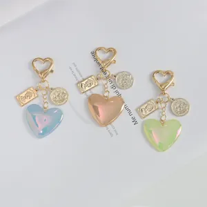Three glittery heart charms with gold buckles, queen portraits and sailboat coin tags
