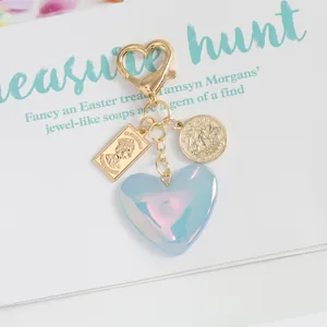 Macro view of blue glitter heart keychain with vintage Elizabeth II and sailing ship coins