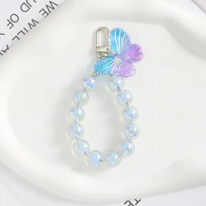 Dettaglio del ciondolo a farfalla con perline sfumate blu e chiusura a moschettone argento