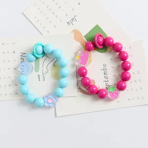 Detailansicht bunter Handyketten aus Acrylperlen mit süßen Smiley- und Blumen-Anhängern