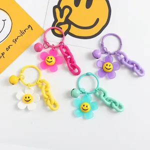 Gros plan de porte-clés fleurs souriantes en acrylique coloré avec clochettes