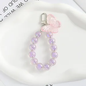 Dettaglio portachiavi con farfalla rosa e perline acriliche viola cangianti di lusso