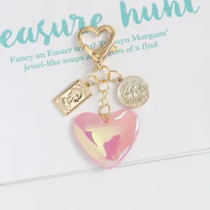 Detail of pink aurora heart charm and vintage queen relief coin keychain pendant