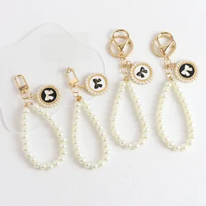Elegant pearl bow keychain set with gold metal lobster clasp for bags and phone cases