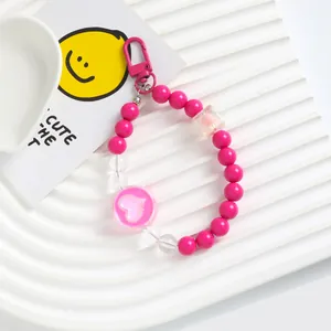Close-up detail of a vibrant pink heart acrylic beaded phone strap and keychain pendant
