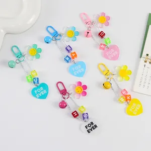 Vue à plat de porte-clés colorés en acrylique avec tournesols, cœurs, cloches et perles