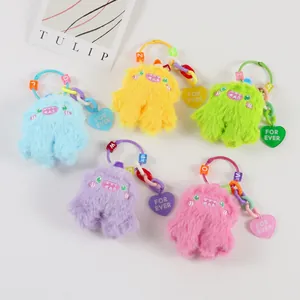 Detail of colorful plush monster keychains with letter beads and heart charms