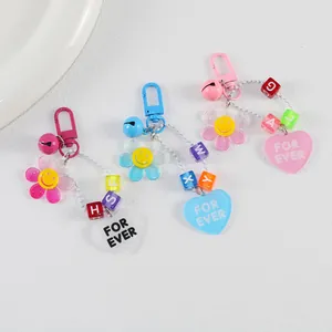 Trois porte-clés tournesol en acrylique coloré avec smileys et pendentifs cœur