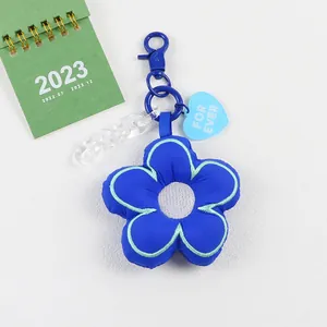 Detail van blauwe pluche bloem sleutelhanger met transparante ketting en hart