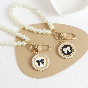 Macro detail of bead strap with pearl bow pendant and number 5 on textured surface