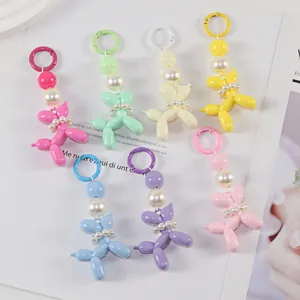 Detail of colorful resin balloon dog keychains with faux pearl collars and matching hooks