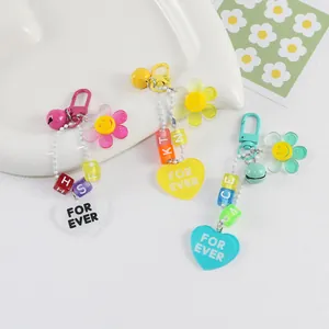 Lot de 3 porte-clés tournesol en acrylique avec lettres et clochettes sur plateau blanc