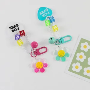 Détail de porte-clés tournesol en acrylique coloré avec perles de lettres et cœurs