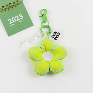 Detail van groene stoffen bloemhanger met acryl ketting en hartvormige hanger