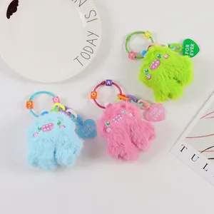 Detailed view of colorful plush monster charms with heart tags and letter beads