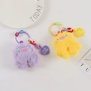 Cute plush monster charms in purple and yellow with colorful chains and heart tags