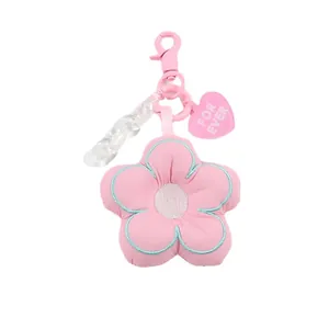 Roze pluche bloem sleutelhanger met borduursel en hart hanger op een witte achtergrond