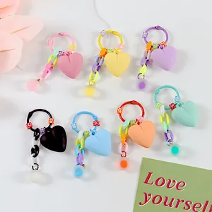 Vista piatta di portachiavi a cuore colorati con perline sorridenti e catene in plastica