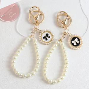 Elegant pearl bow keychain with golden metal ring and number 5 decorative pendant