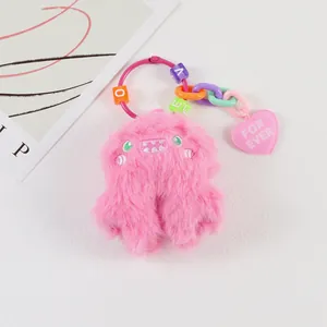Macro detail of pink plush monster keychain with LOVE beads and a pink heart charm