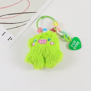Close-up of neon green monster plush keychain with colorful beads and heart charm