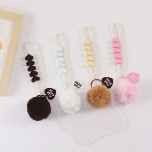 Detailed view of heart pearl faux fur pompom keychains in multiple soft pastel colors