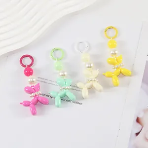 Detail of colorful resin balloon dog keychains with pearls on a white tray