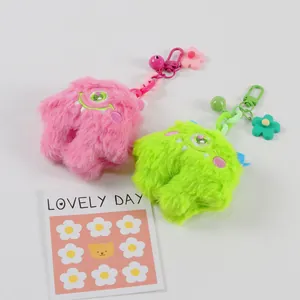 Detailed macro view of pink and green plush monster keychains with colorful charms