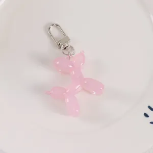 Detailed close-up of a pink resin balloon dog pendant with silver metallic spring clasp