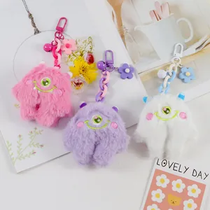 Detail of plush monster keychains in pink purple white with charms and bells