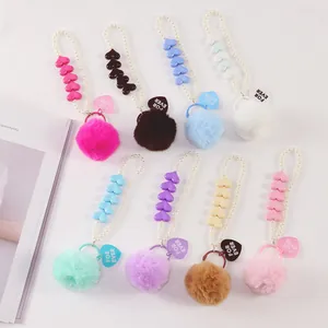 Detailed collection of plush ball keychains with pearls and heart-shaped charms