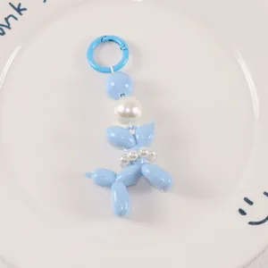 Close-up of sky blue balloon dog keychain featuring elegant white pearl decorations