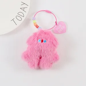 Detail of pink plush monster keychain with FOR EVER heart tag and colorful beads