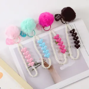 Detail of colorful faux fur pompom keychains with pearl beads and heart charms