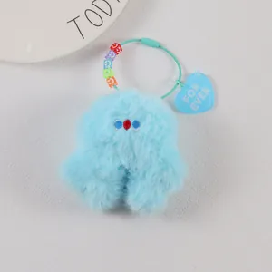 Close-up of blue plush monster keychain with colorful smile beads and heart charm