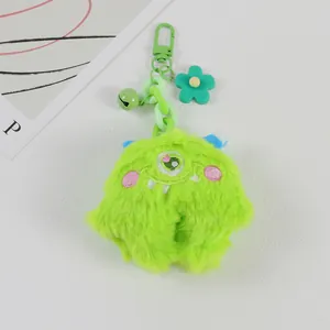 Close-up of bright green fuzzy monster keychain with single eye and flower charm