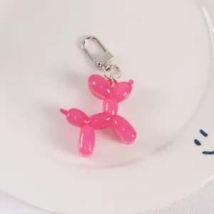 Detailed view of pink jelly resin balloon dog keychain in a white decorative dish