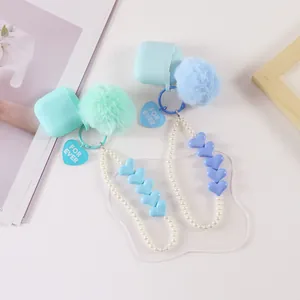Detail of heart pearl keychain sets with faux fur pom poms and silicone case charms