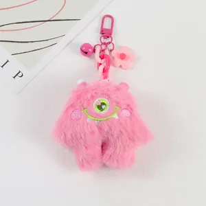 Pink plush monster keychain featuring soft faux fur, a bell and a cute floral pendant