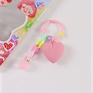 Dettaglio di un portachiavi rosa a forma di cuore con perline smiley e ciondolo